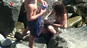 A horny teen babe rides her boyfriend on the beach while voyeurs watch