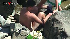 A horny teen babe rides her boyfriend on the beach while voyeurs watch