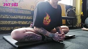 Tattooed Alternative Young Girl Stretching Exercises At The Gym