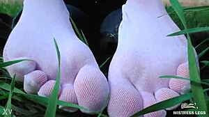 Goddess feet tease in cute white socks while wearing jeans on a spring grass field