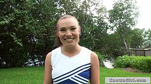 Busty cheerleader shows off outdoors.