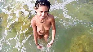 Горячая девчонка дразнит, раздеваясь на публичном пляже