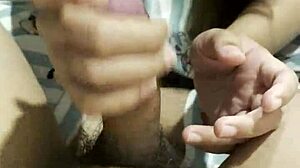 feeling the intense pleasure as the asian girl gives her boyfriend an amazing handjob in their bedroom