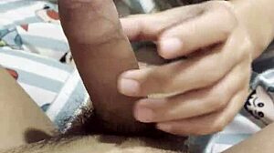 feeling the intense pleasure as the asian girl gives her boyfriend an amazing handjob in their bedroom