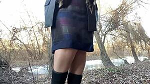 mature busty woman in stockings and dress relieves herself outdoors