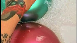 tattooed girl pops balloons in bubbly bath