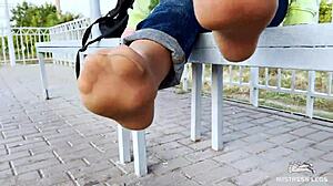 Goddess Teases Tan Nylon Soles and Legs in Blue Jeans on Outdoor Bench