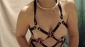 french slave straps into harness for bound submission session