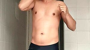 suggestive sexy guy shaves smooth in black beach shorts