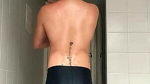 suggestive sexy guy shaves smooth in black beach shorts