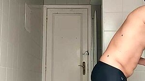suggestive sexy guy shaves smooth in black beach shorts
