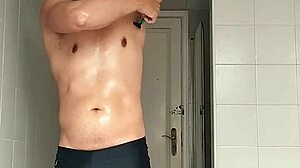 suggestive sexy guy shaves smooth in black beach shorts