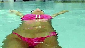 Monika Fox's huge fake tits spill from pink bikini at poolside strut